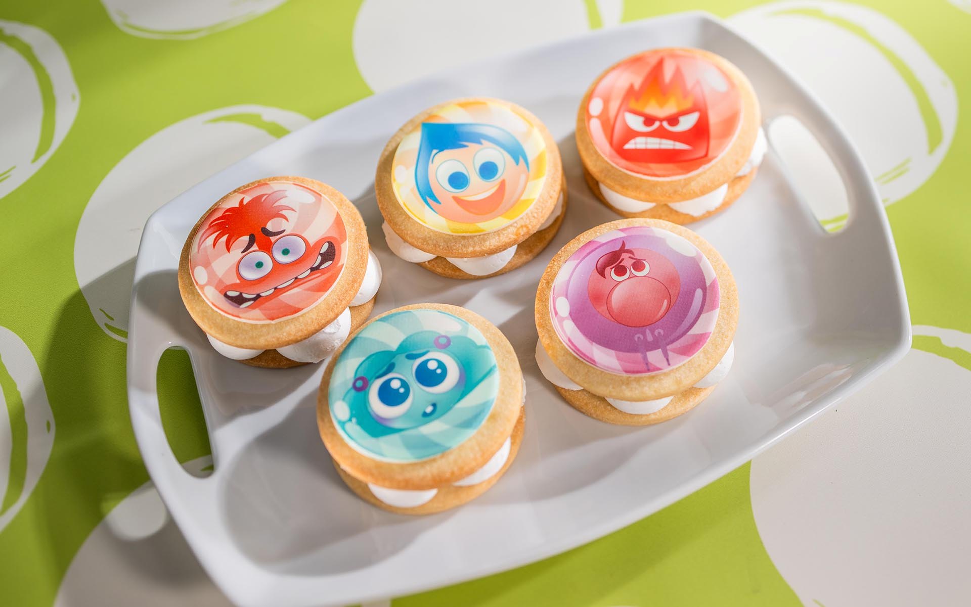 Five Inside Out shortbread sandwich cookies decorated with character faces