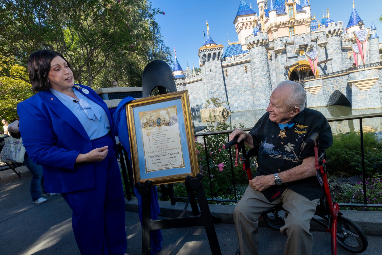 Retired U.S. Navy Capt. E. Royce Williams receives an Honorary Citizen of Disneyland certificate near Sleeping Beauty Castle