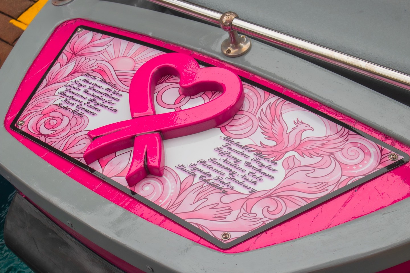 Pink breast cancer awareness ribbon and tribute panel on Monster Mansion boat