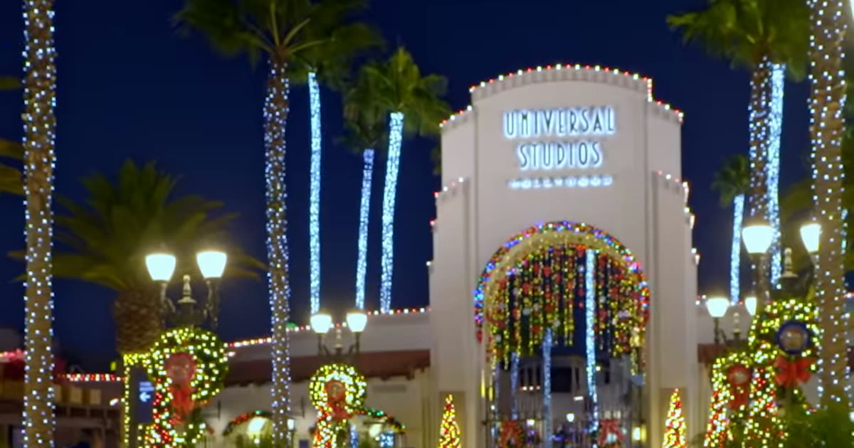 The Universal Studios Hollywood entrance decorated with holiday lights in the park’s official 2026 holiday announcement reel