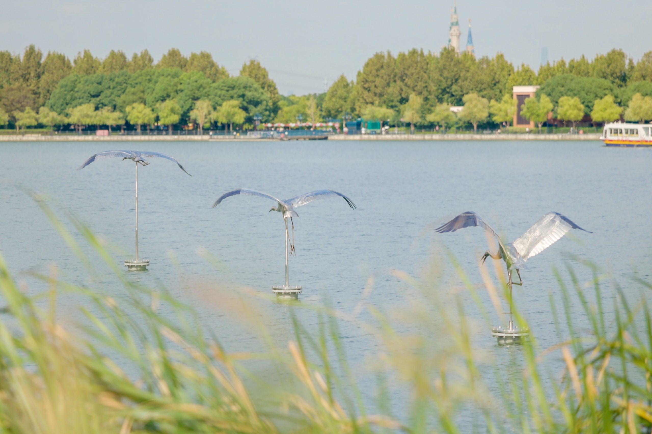 Three Siberian crane sculptures positioned over Wishing Star Lake