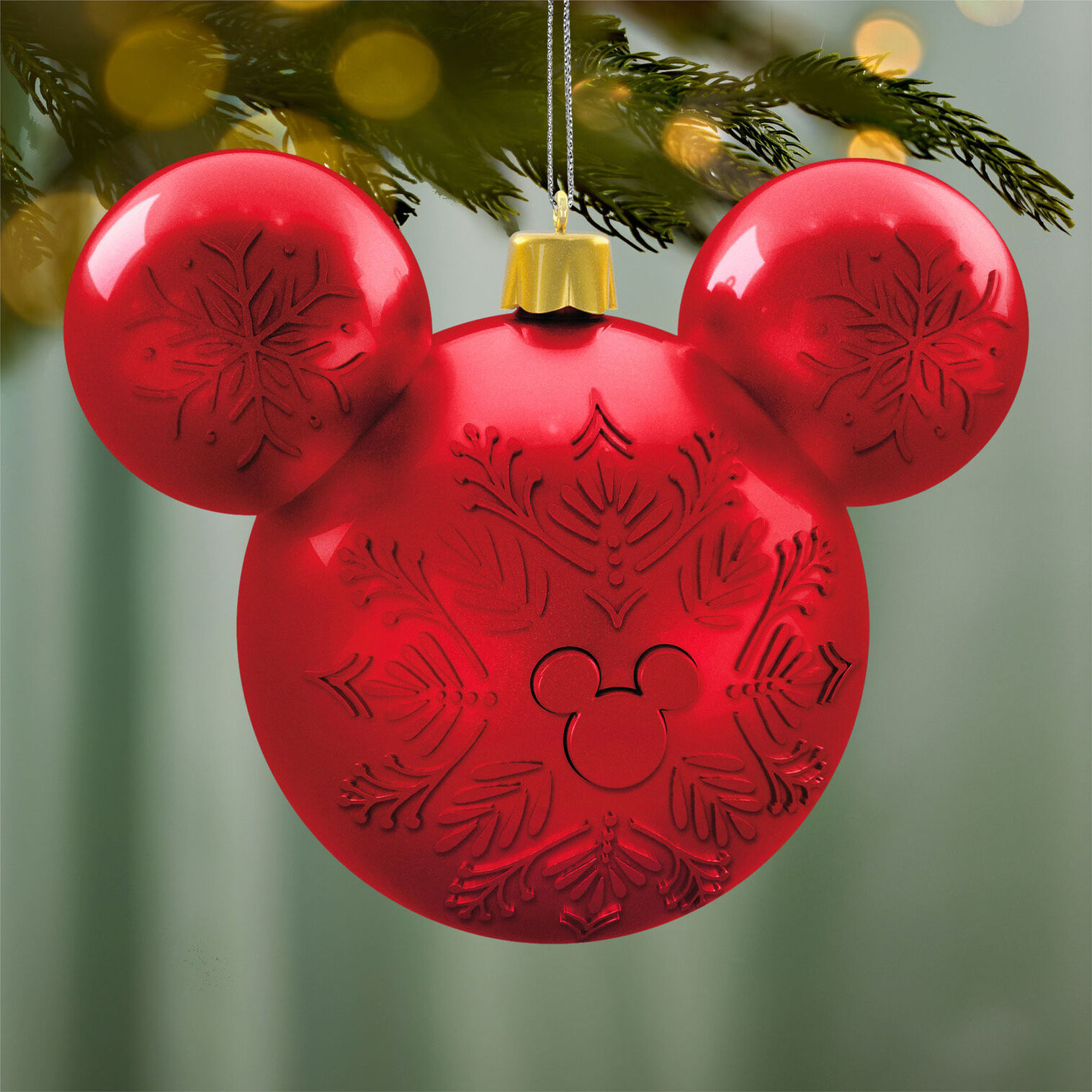 Red Mickey-ears Hallmark ornament hanging on a Christmas tree
