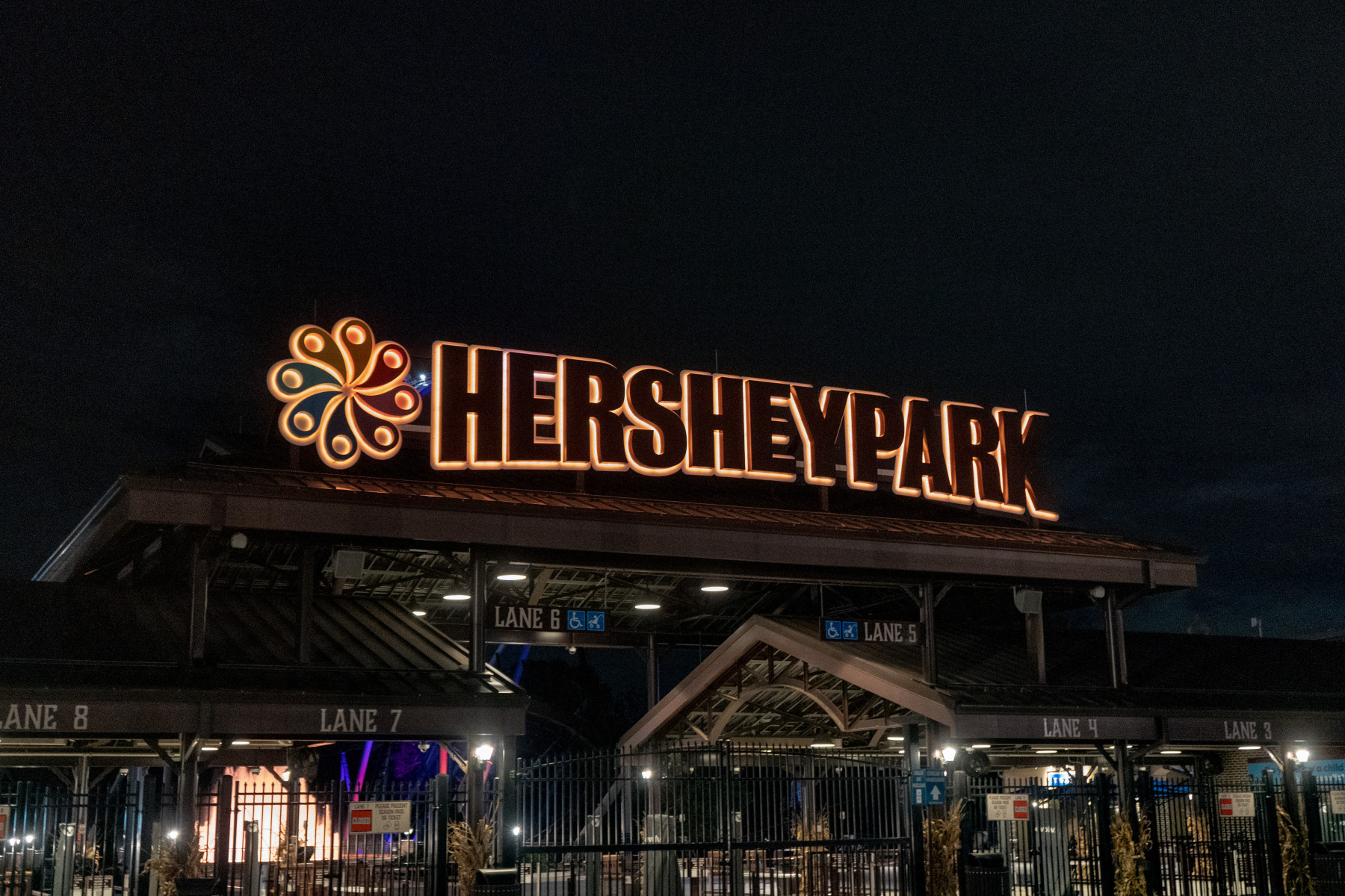 The illuminated Hersheypark entrance and closed front gates at night