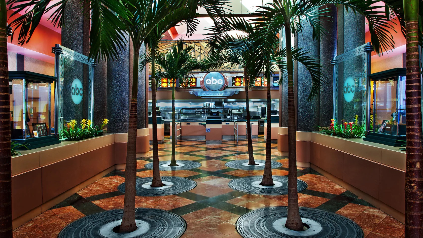 Two rows of palm trees line the Art Deco interior entryway at ABC Commissary in Disney's Hollywood Studios