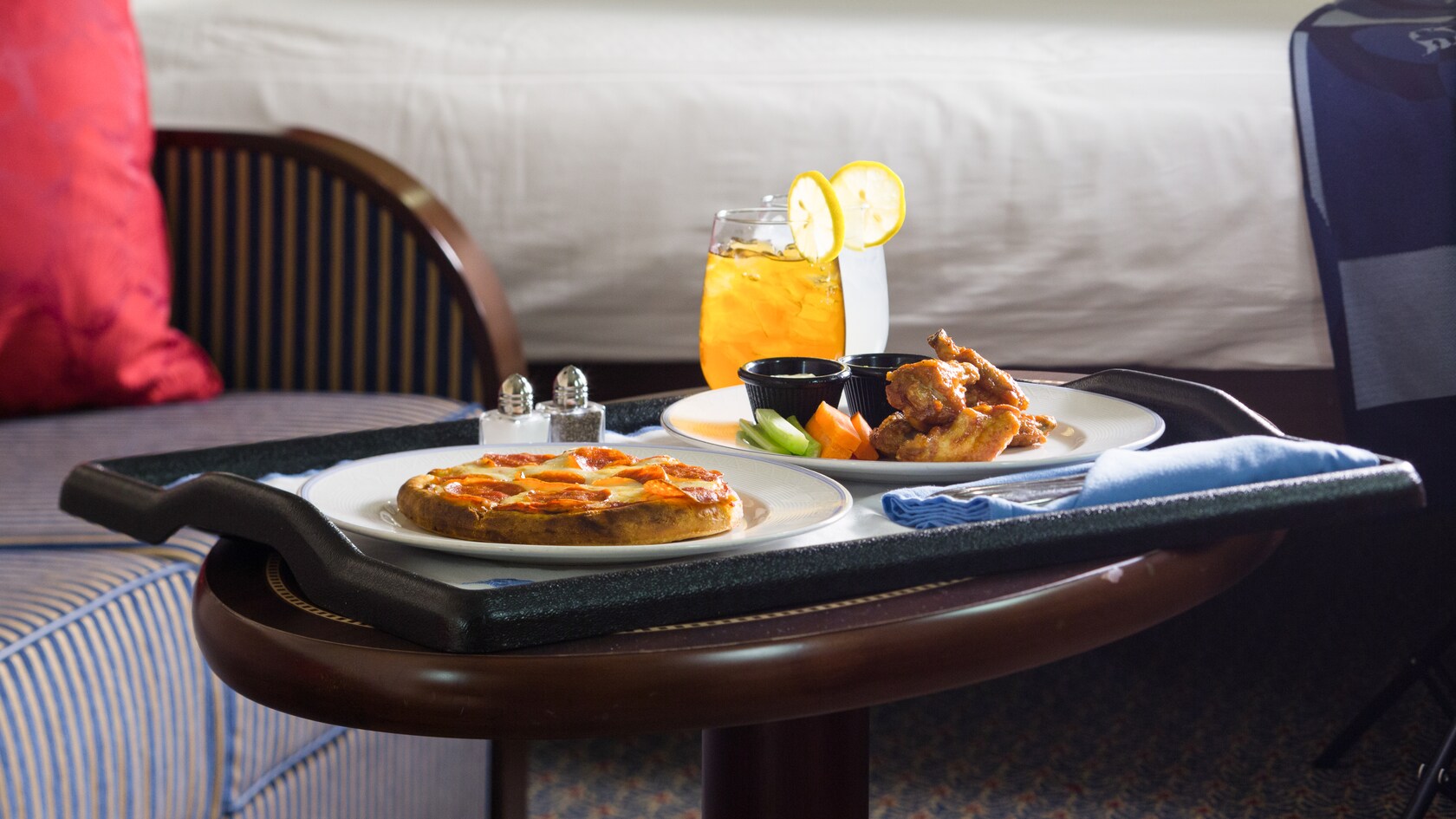 Room service tray with pizza, wings and drinks in a Disney Cruise Line stateroom
