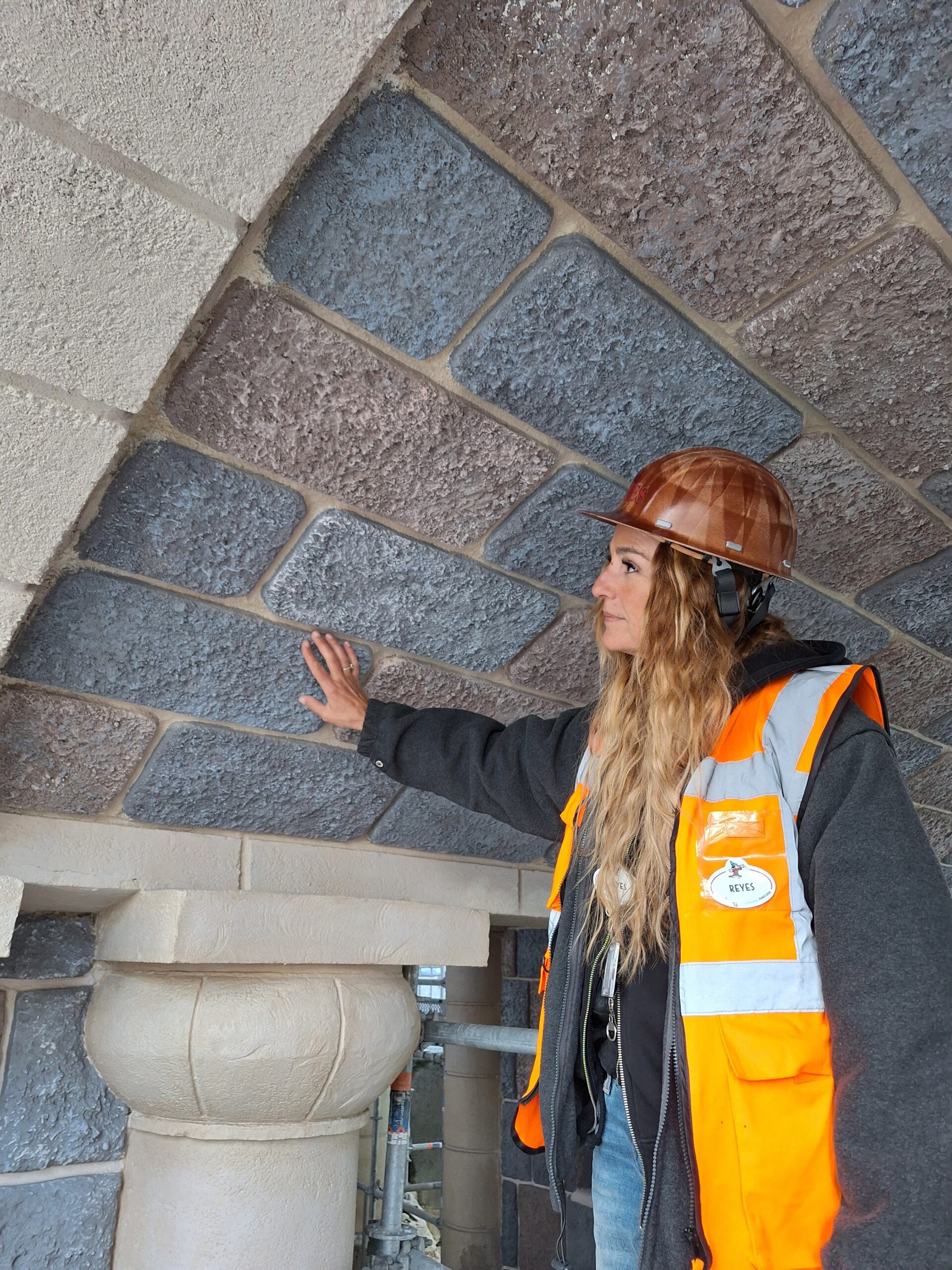 A worker inspects restored stonework beneath the castle bridge
