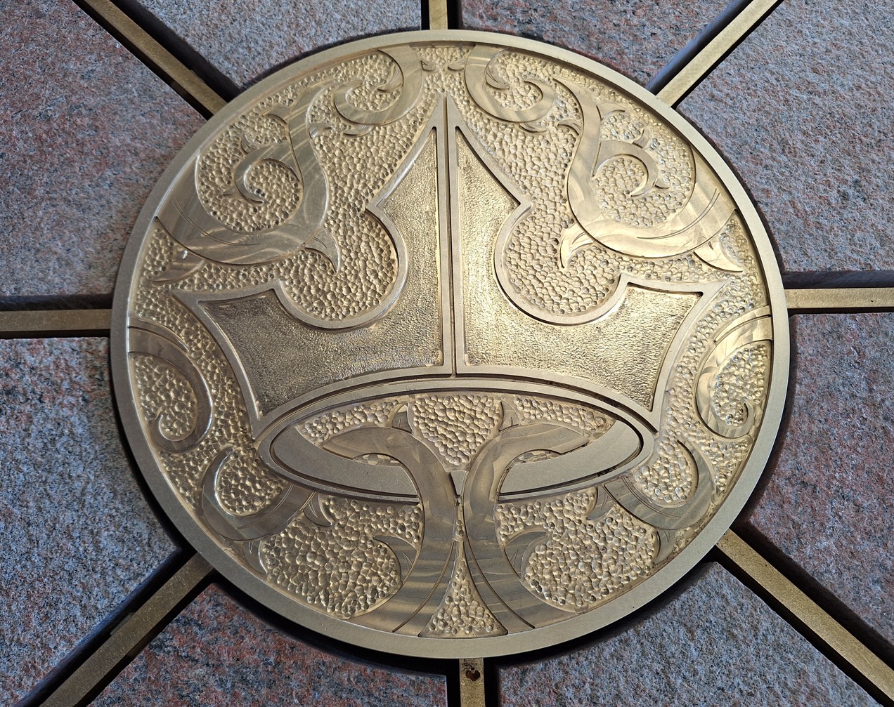 Brass medallion showing Aurora's crown and thorns at the center of the compass rose