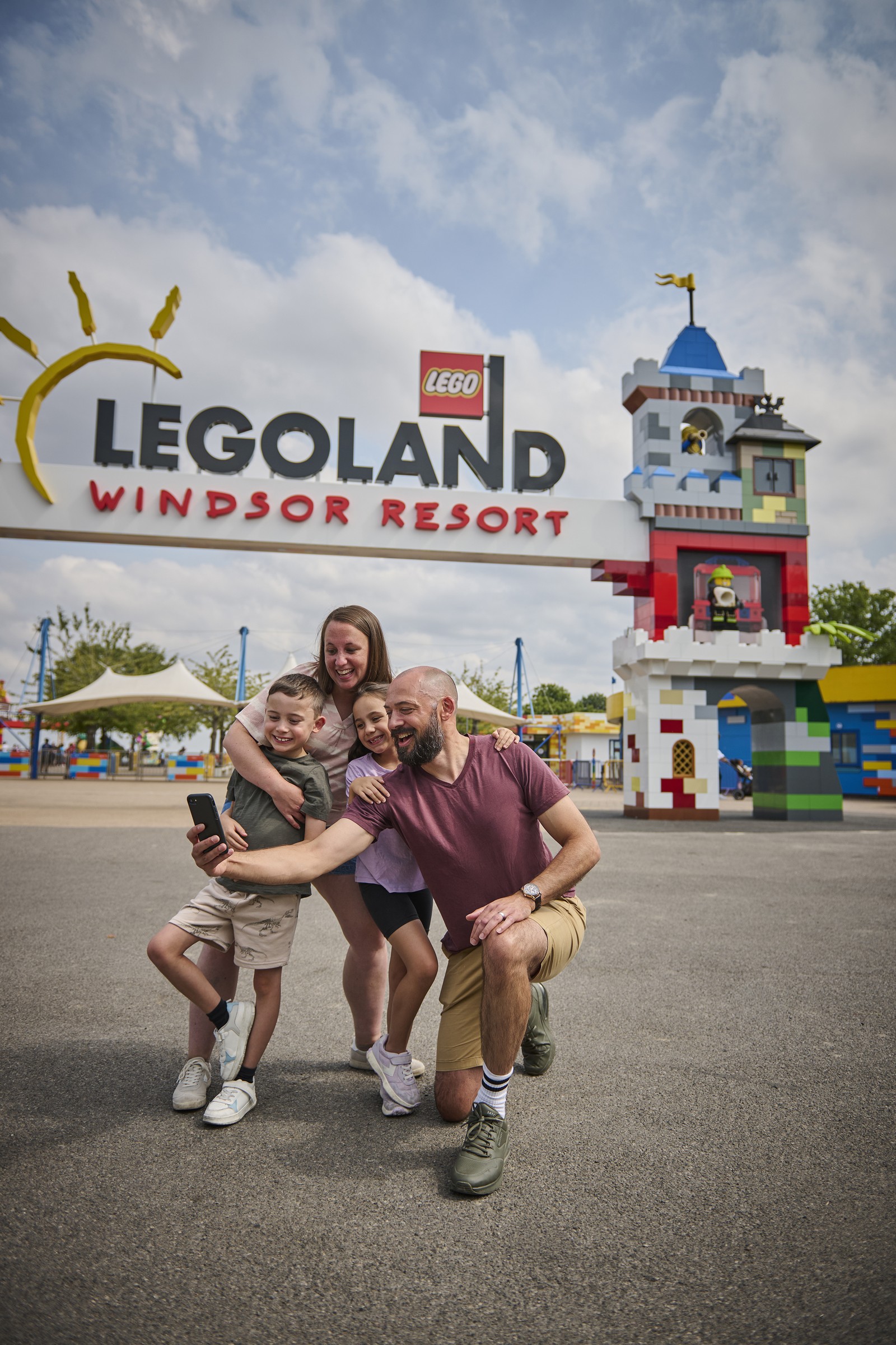 A family takes a selfie outside the LEGOLAND Windsor Resort entrance