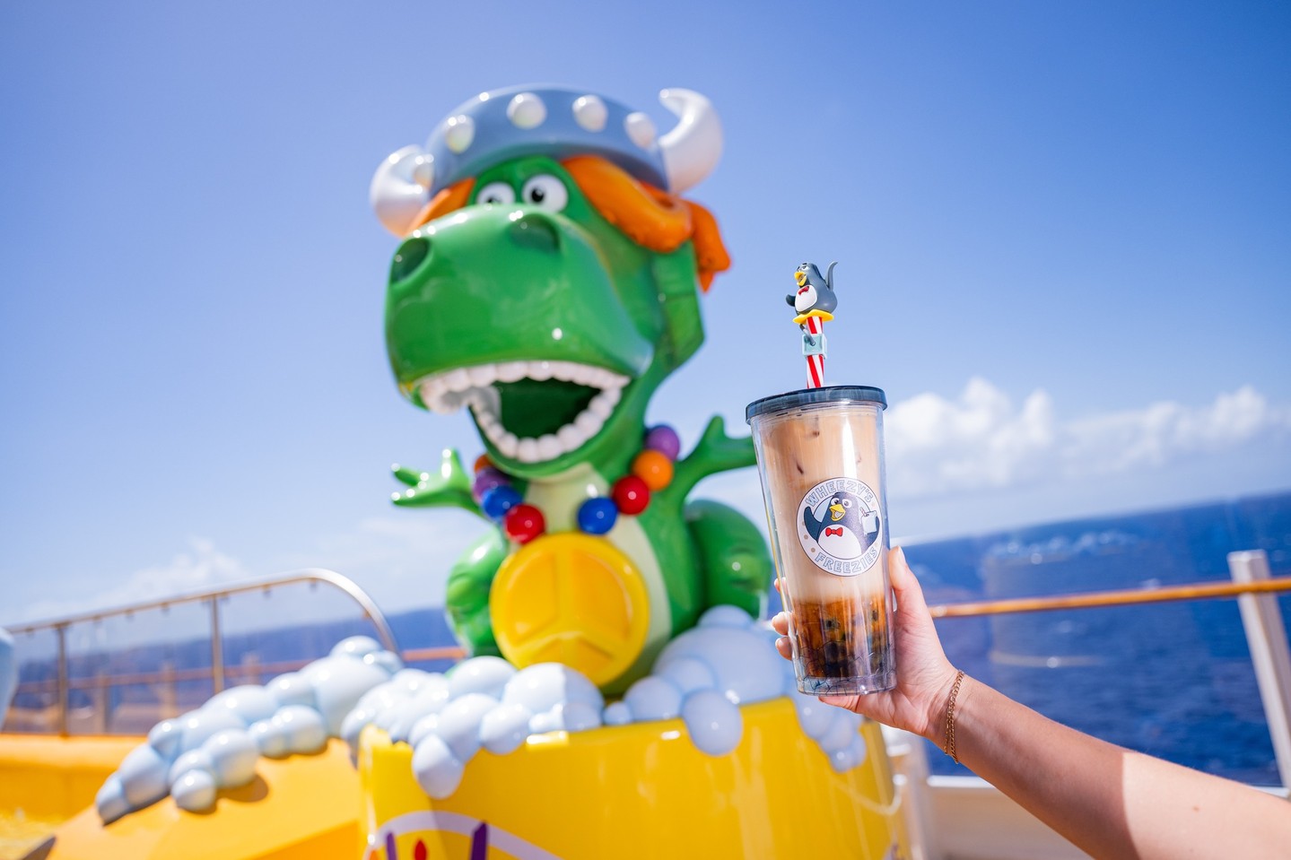 A boba drink held in front of Rex aboard a Disney Cruise Line ship