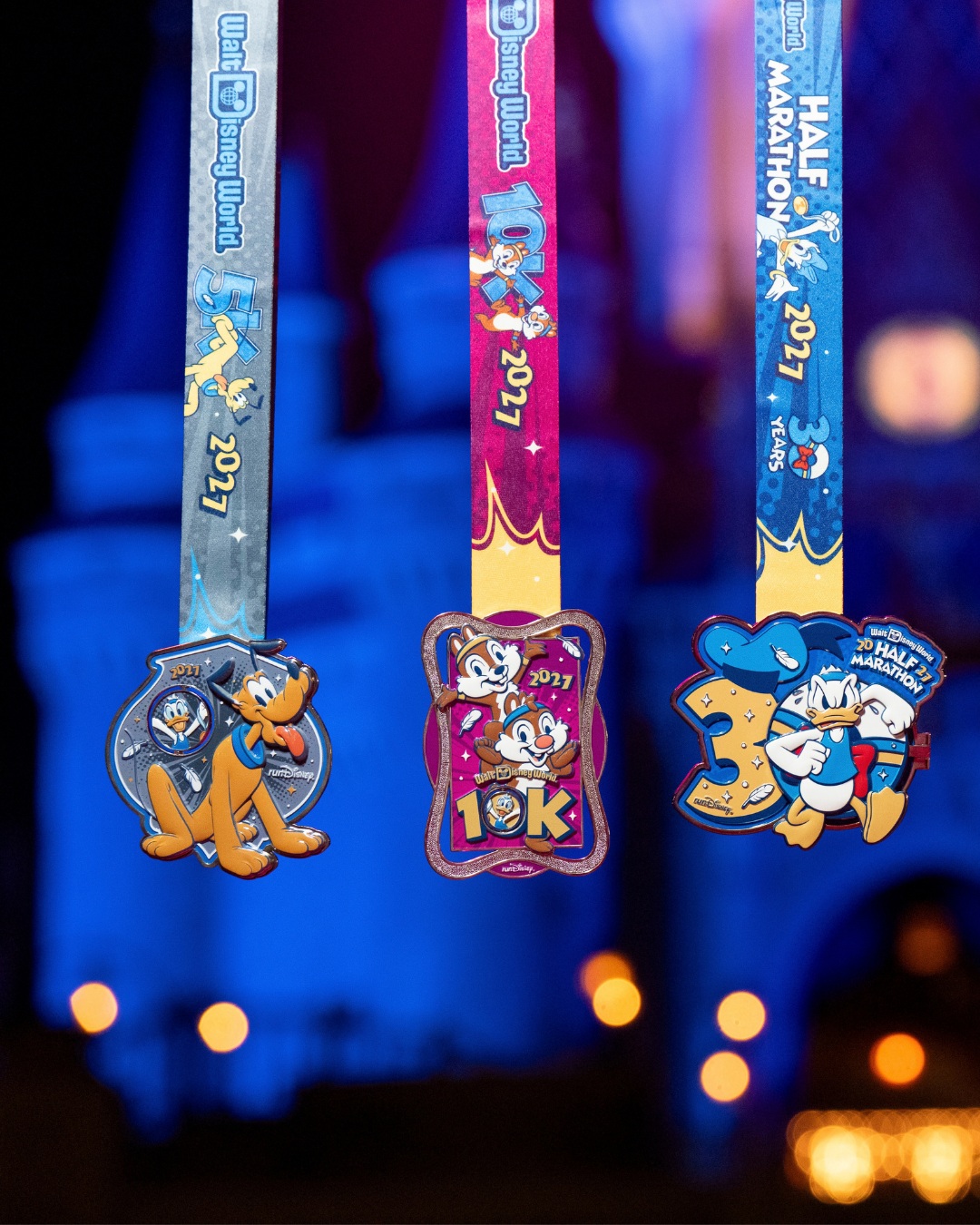 Three 2027 Walt Disney World Marathon Weekend medals displayed by runDisney