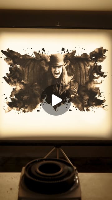 A projector displays a dark illustrated figure in a bare room in a Halloween Horror Nights teaser
