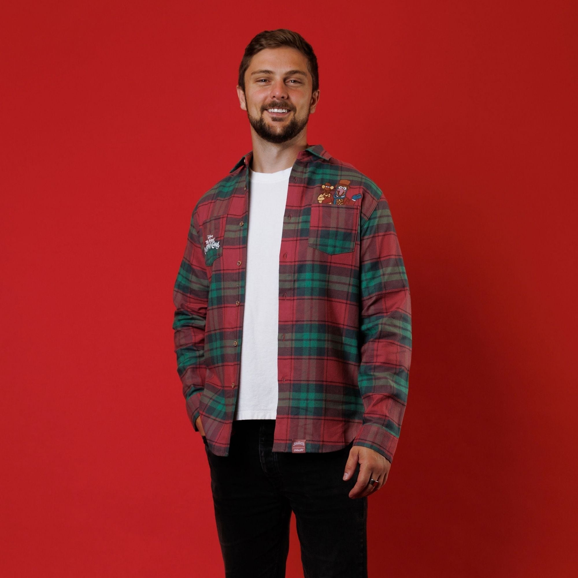 A model wears the red-and-green plaid Cakeworthy Muppets Christmas Carol flannel from the front
