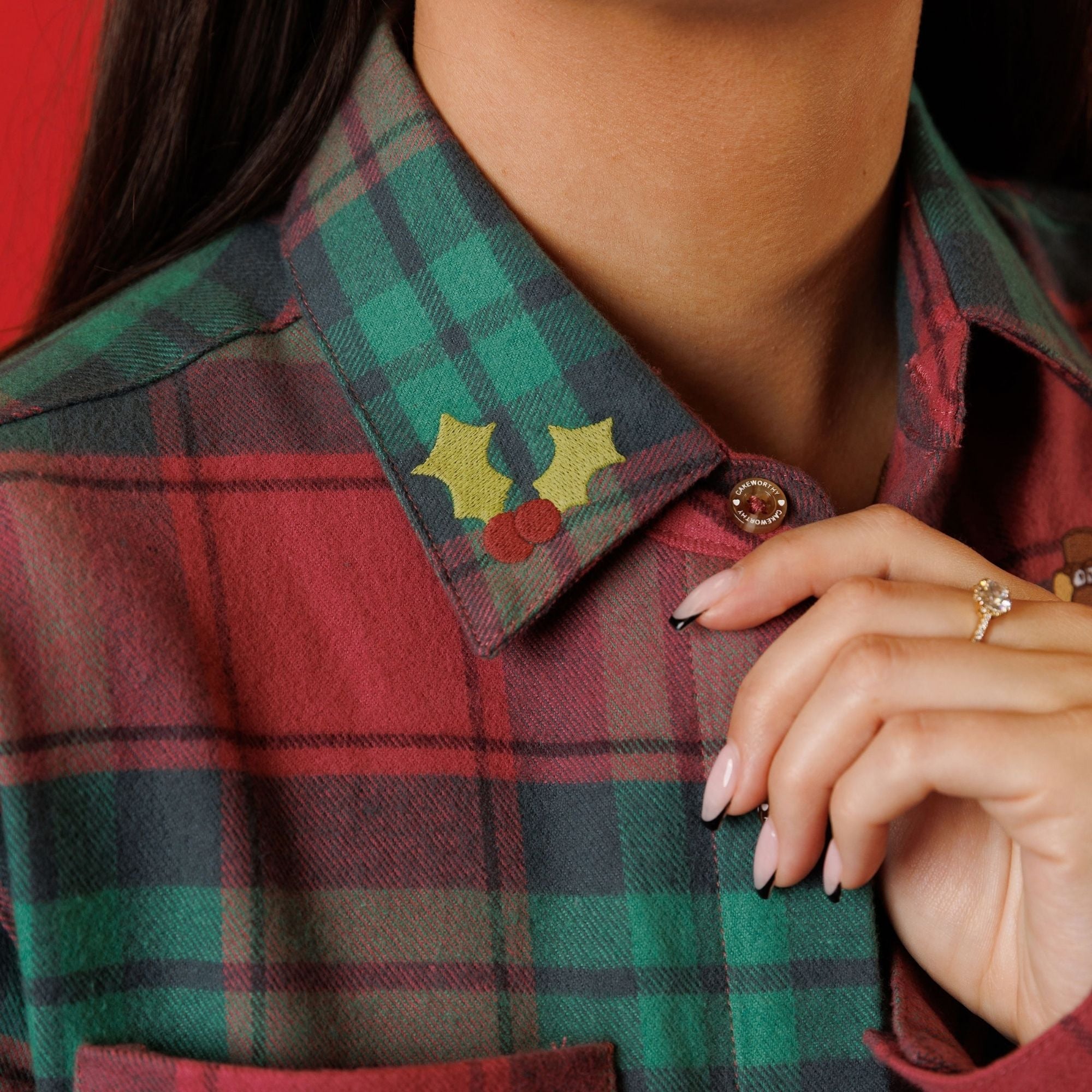 Close view of holly printed on the Cakeworthy flannel collar