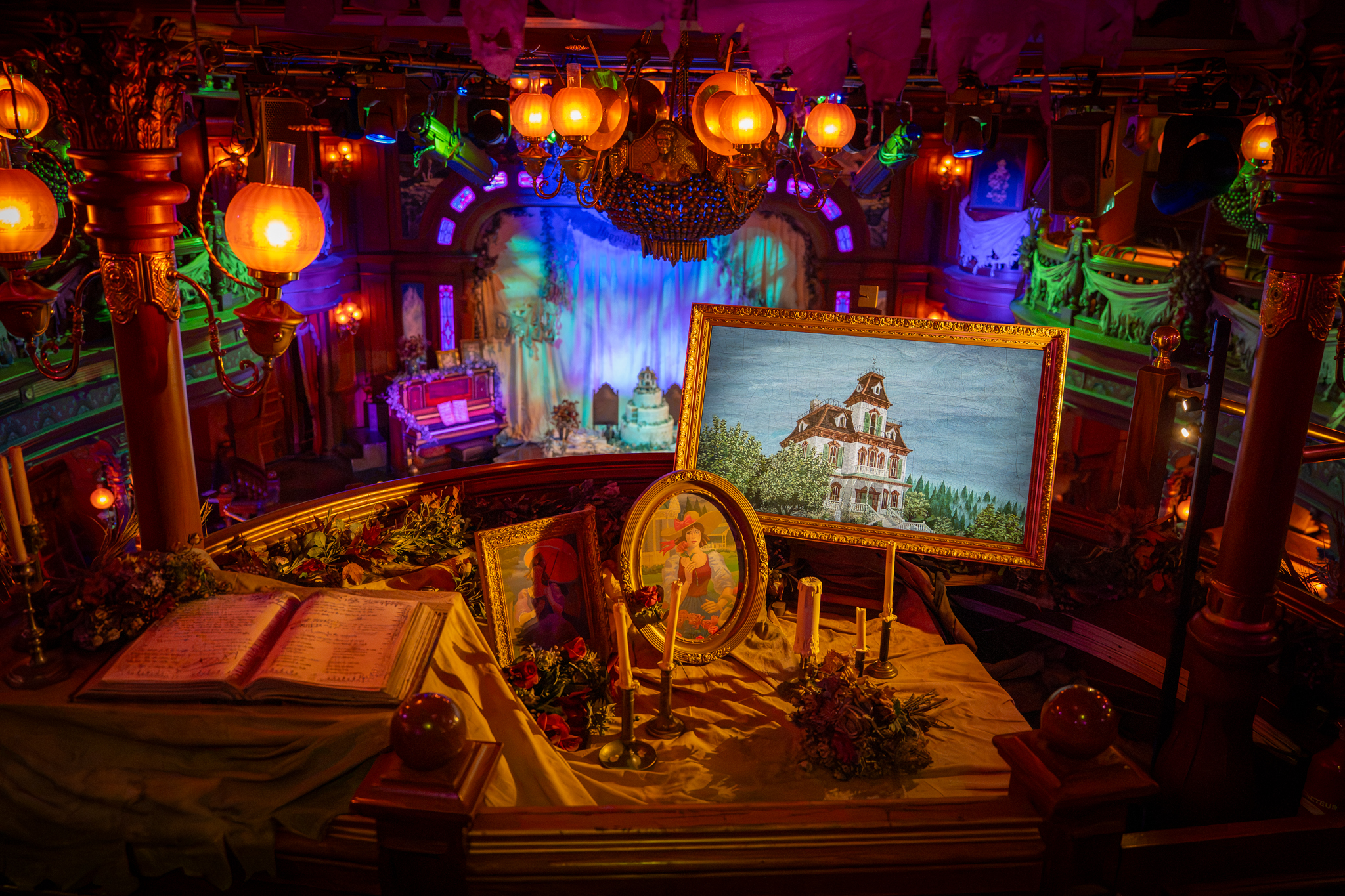 Framed portraits, candles and Halloween decorations overlooking The Unlucky Nugget Saloon stage