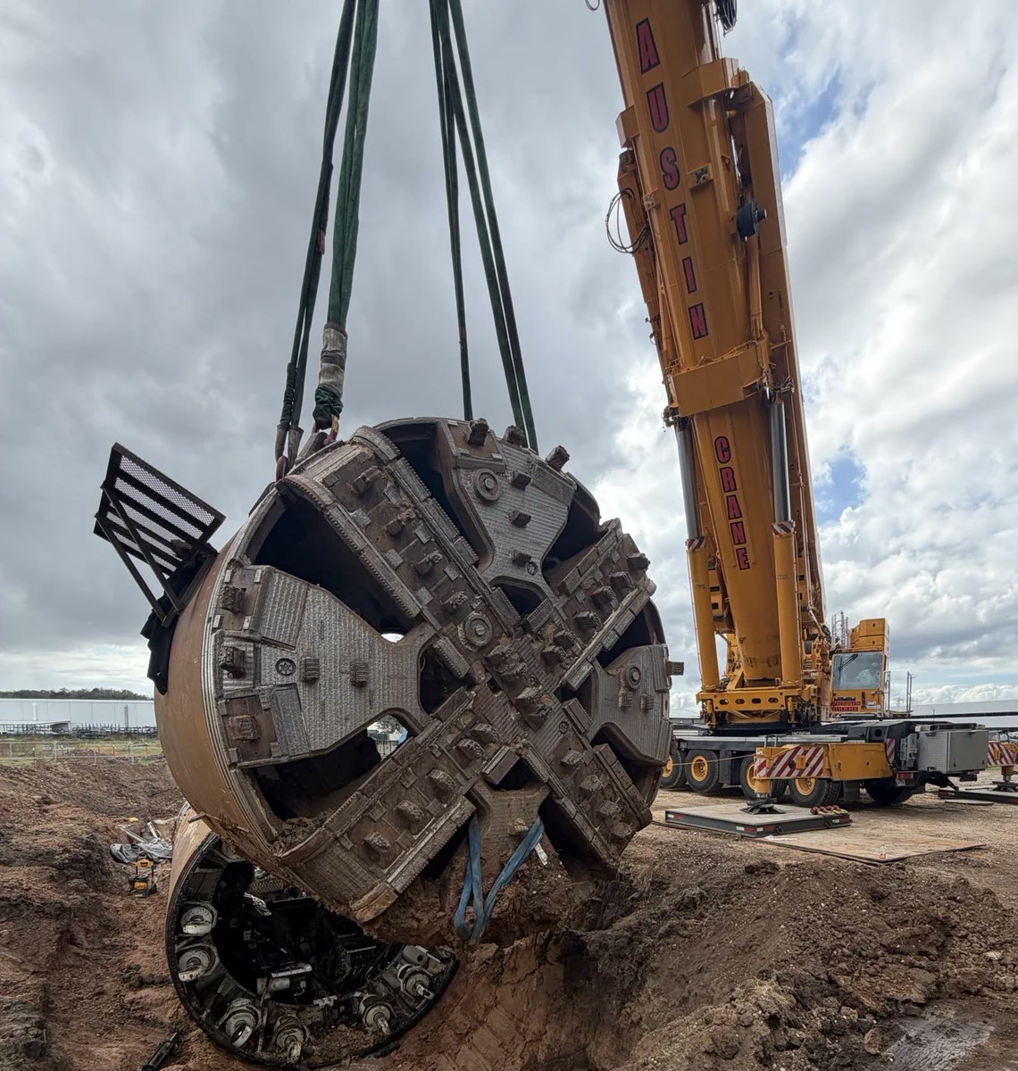 Prufrock-5 tunnel-boring machine being lowered beside a crane at Morgan’s Inclusion Campus