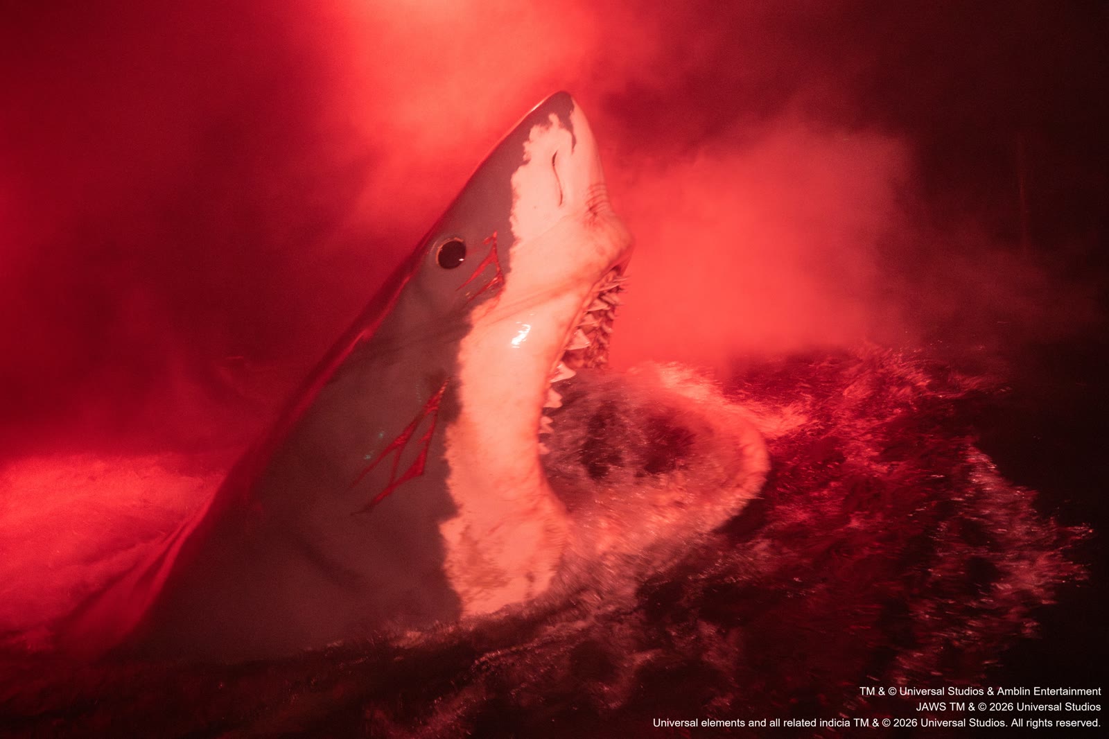 The Jaws shark rises through red-lit water and mist at Universal Studios Japan