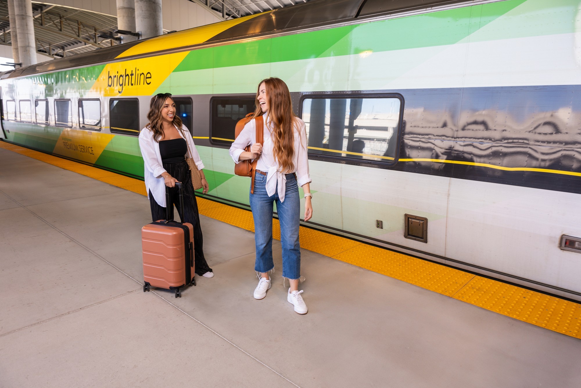 Travelers board a Brightline train with luggage