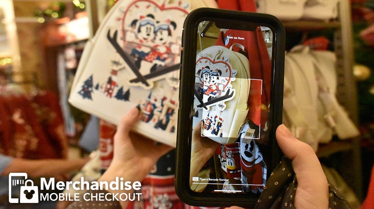 A guest scans Disney merchandise with a phone for mobile checkout