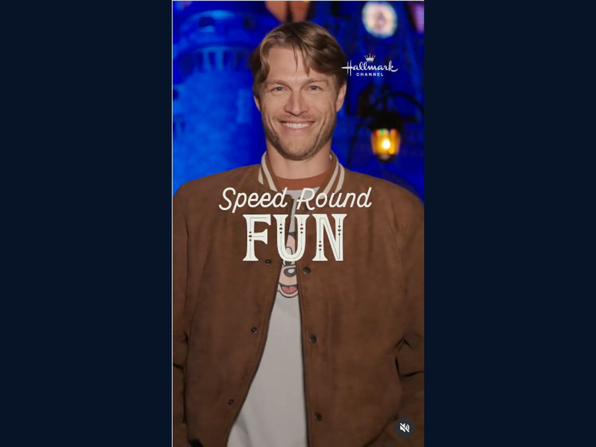 A smiling Holiday Ever After cast member appears in front of Cinderella Castle during the Disney character quiz