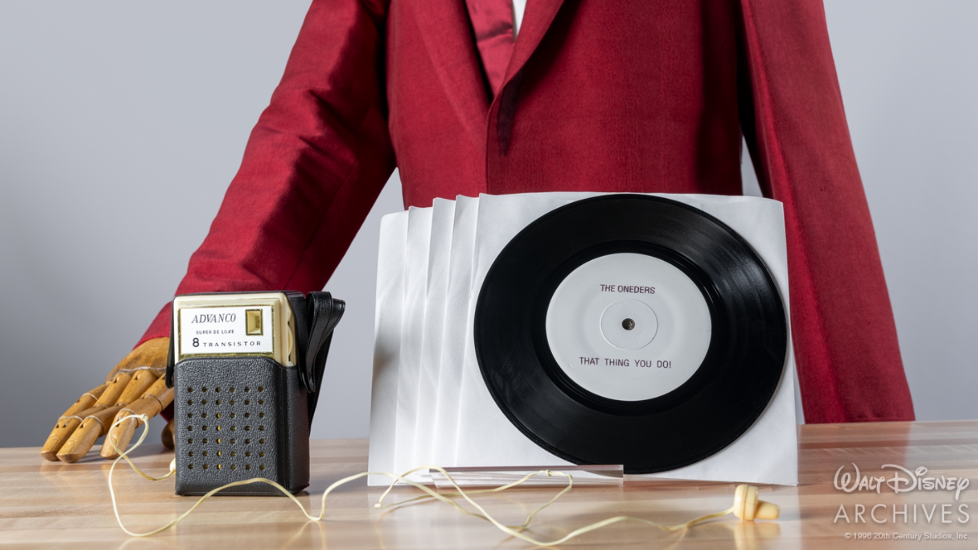 The Wonders’ red suit, transistor radio and prop That Thing You Do! single preserved by the Walt Disney Archives