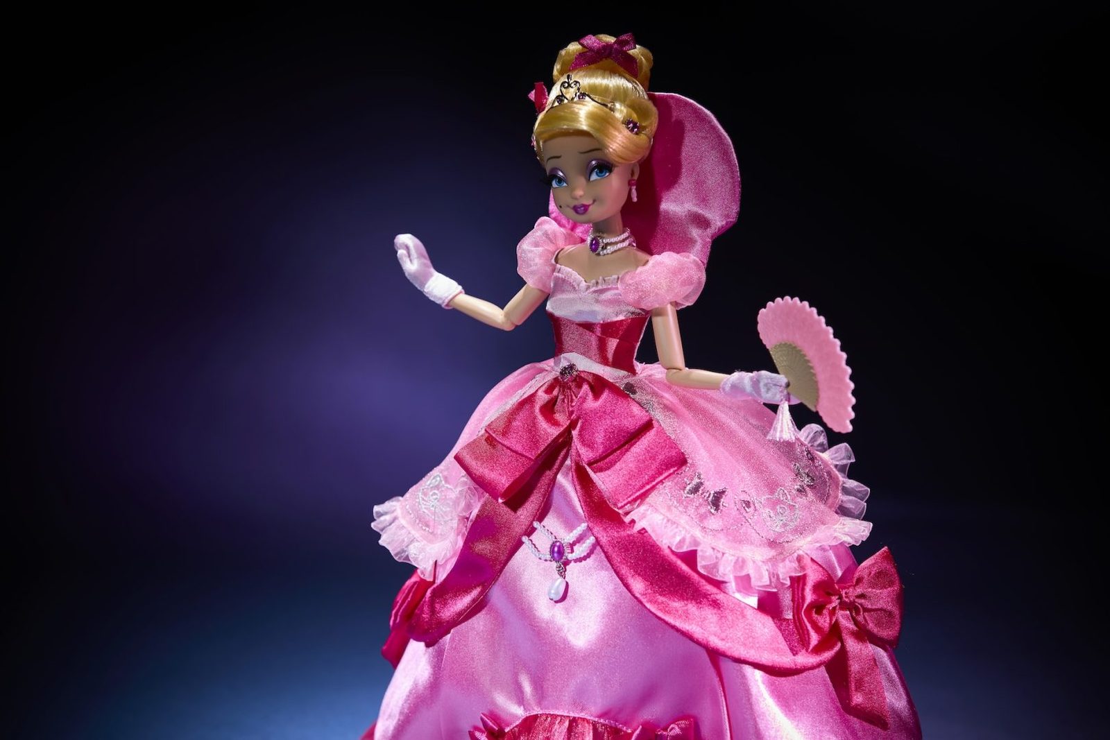 Lottie Designer Doll holding a pink fan in a ballroom dress