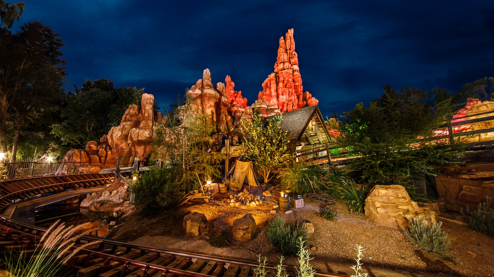 Big Thunder Mountain Railroad winding through the Disneyland landscape at night