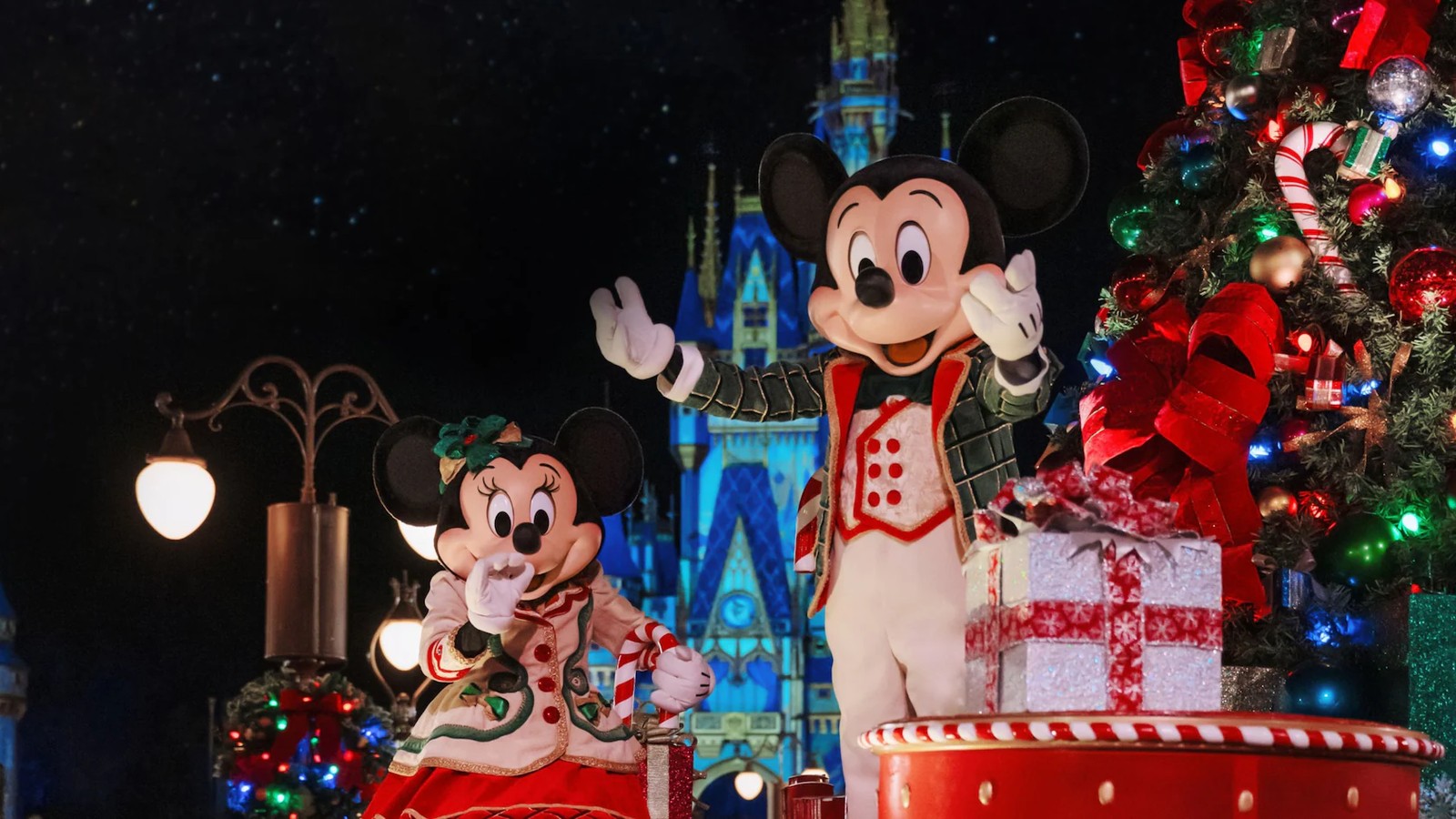 Mickey Mouse and Minnie Mouse in holiday costumes with Christmas decorations at Magic Kingdom