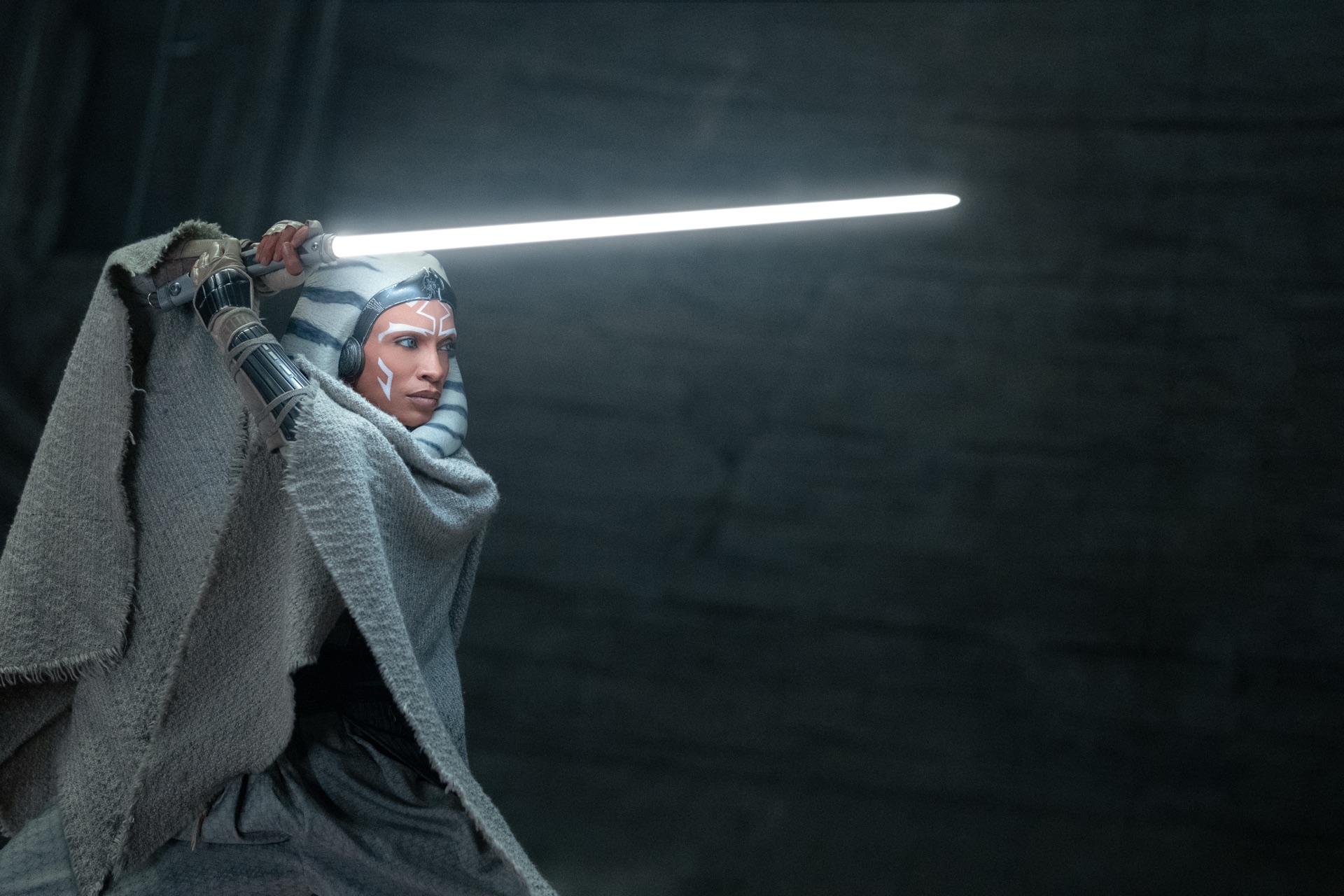 Ahsoka Tano raises a white lightsaber in an official Star Wars publicity image