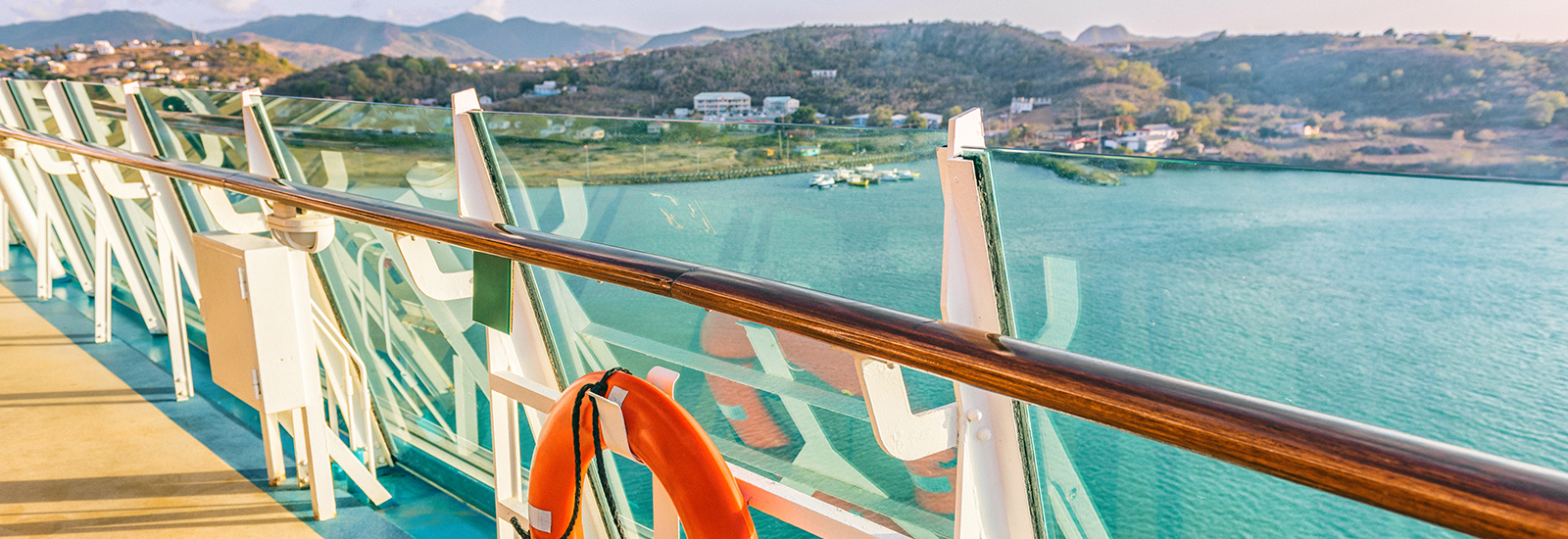 A life ring hangs on the deck of an ocean cruise ship overlooking the water