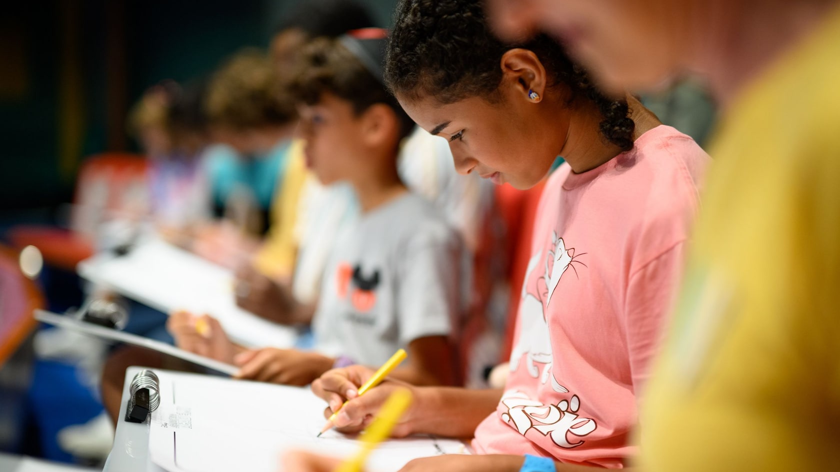Guests focused on drawing during an Animation Academy class at Disney California Adventure