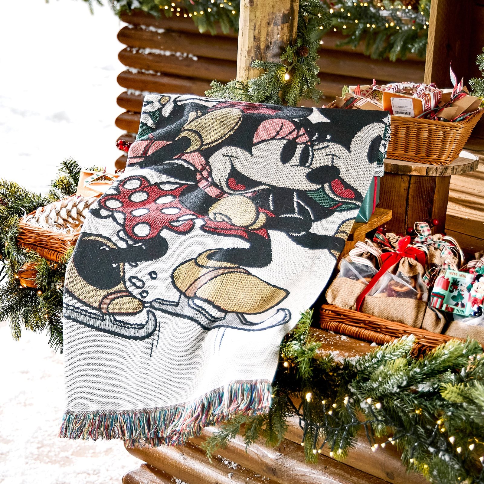 Mickey and Minnie holiday throw blanket draped over a wooden bench