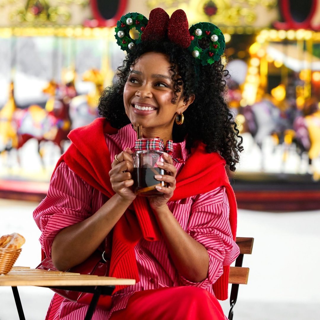 Model wearing the green Minnie Mouse holiday wreath ear headband