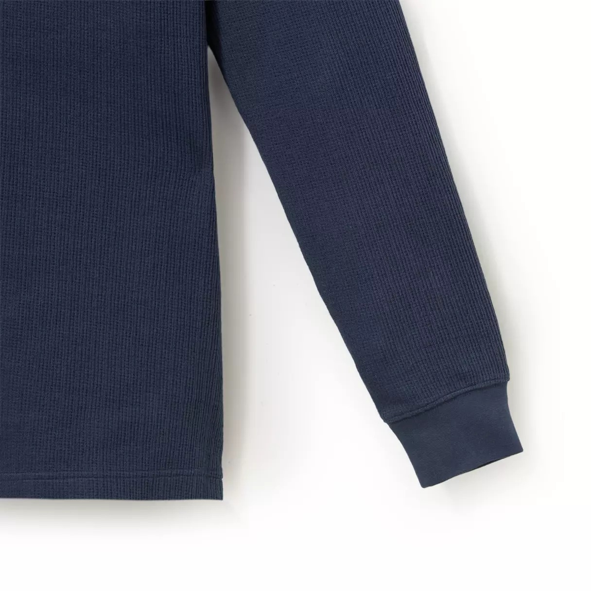 Close view of the navy waffle-weave fabric and embroidered characters