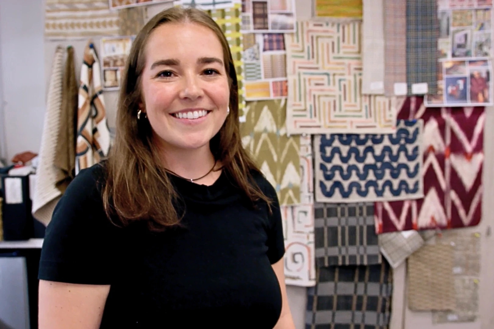 A Richloom designer stands in front of textile samples