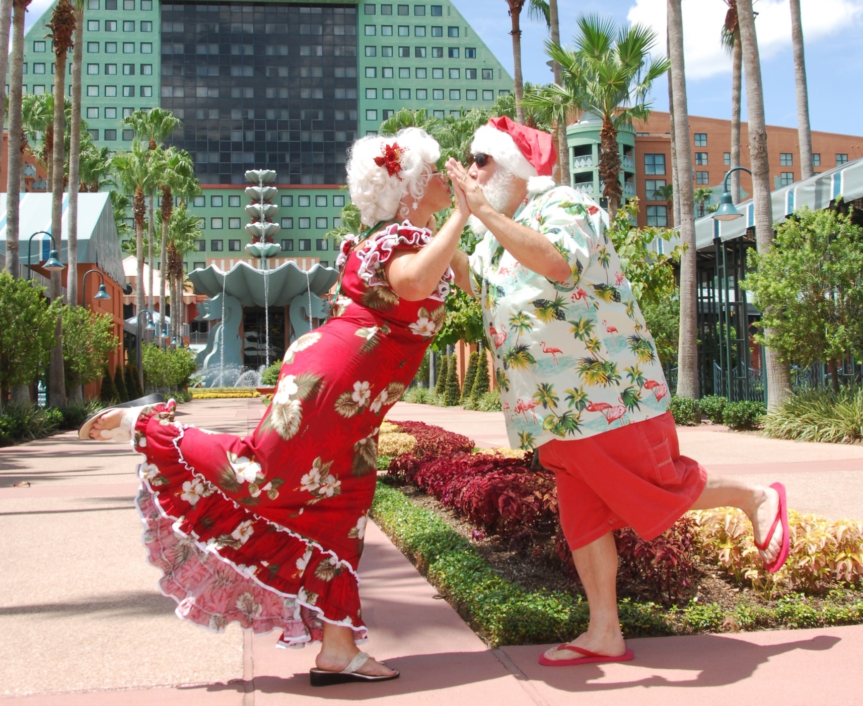 Santa and Mrs. Claus in tropical holiday outfits outside the Walt Disney World Swan and Dolphin