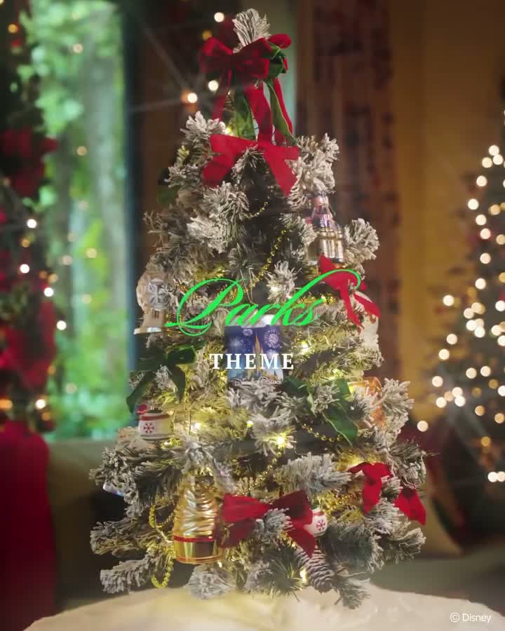 A flocked Walt Disney World Parks Theme holiday tree with attraction ornaments and red bows