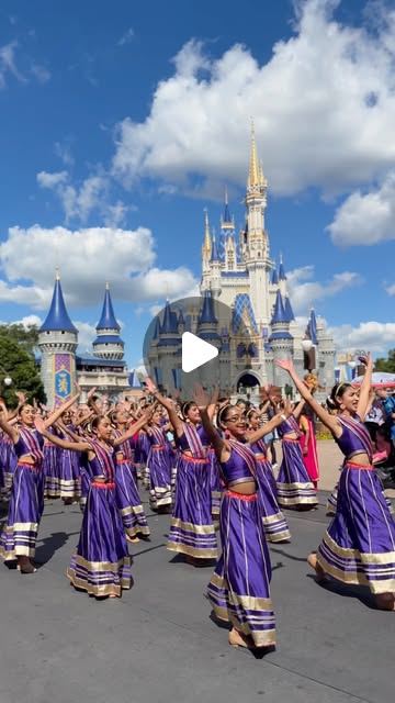 Diwali Dance Fest performers in purple costumes dance on Main Street U.S.A. with Cinderella Castle behind them