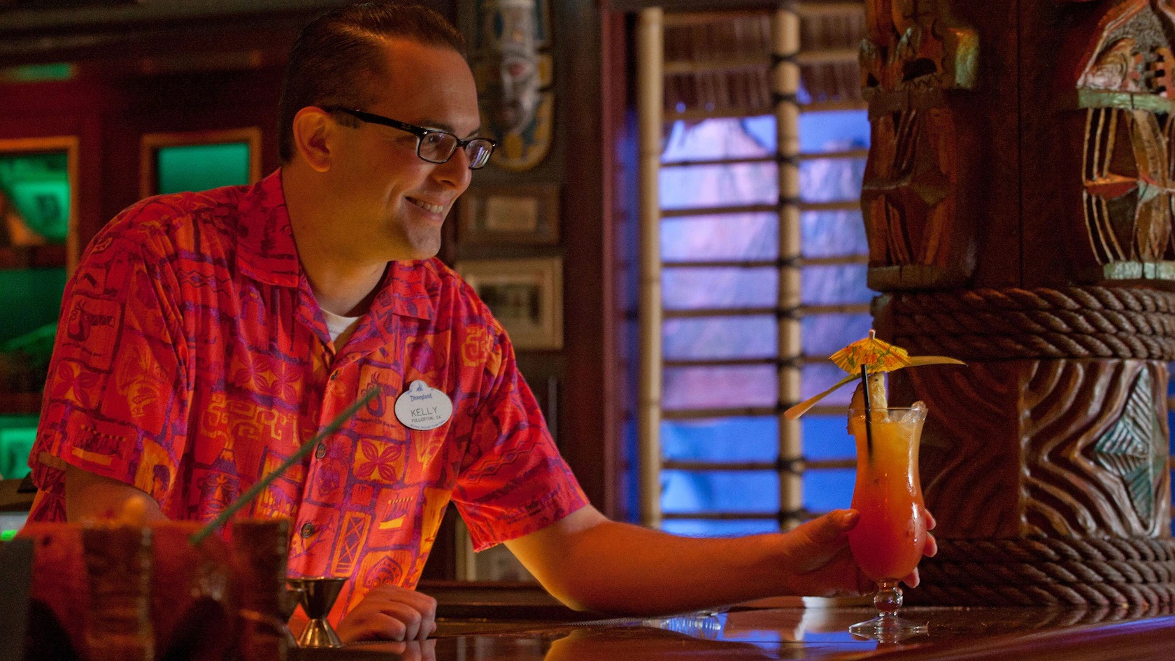A Trader Sam’s bartender serves a tropical cocktail topped with a pineapple slice and umbrella