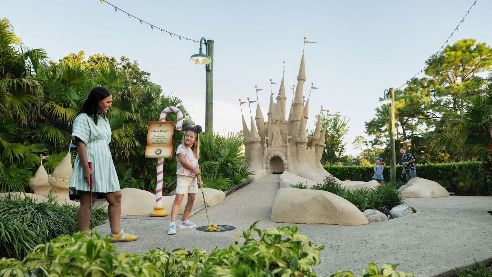 A family plays miniature golf beside a sand castle at Winter Summerland