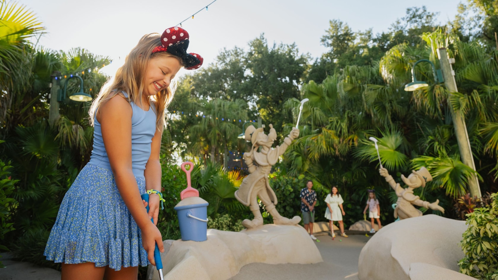 A child plays miniature golf beside Donald Duck figures at Winter Summerland