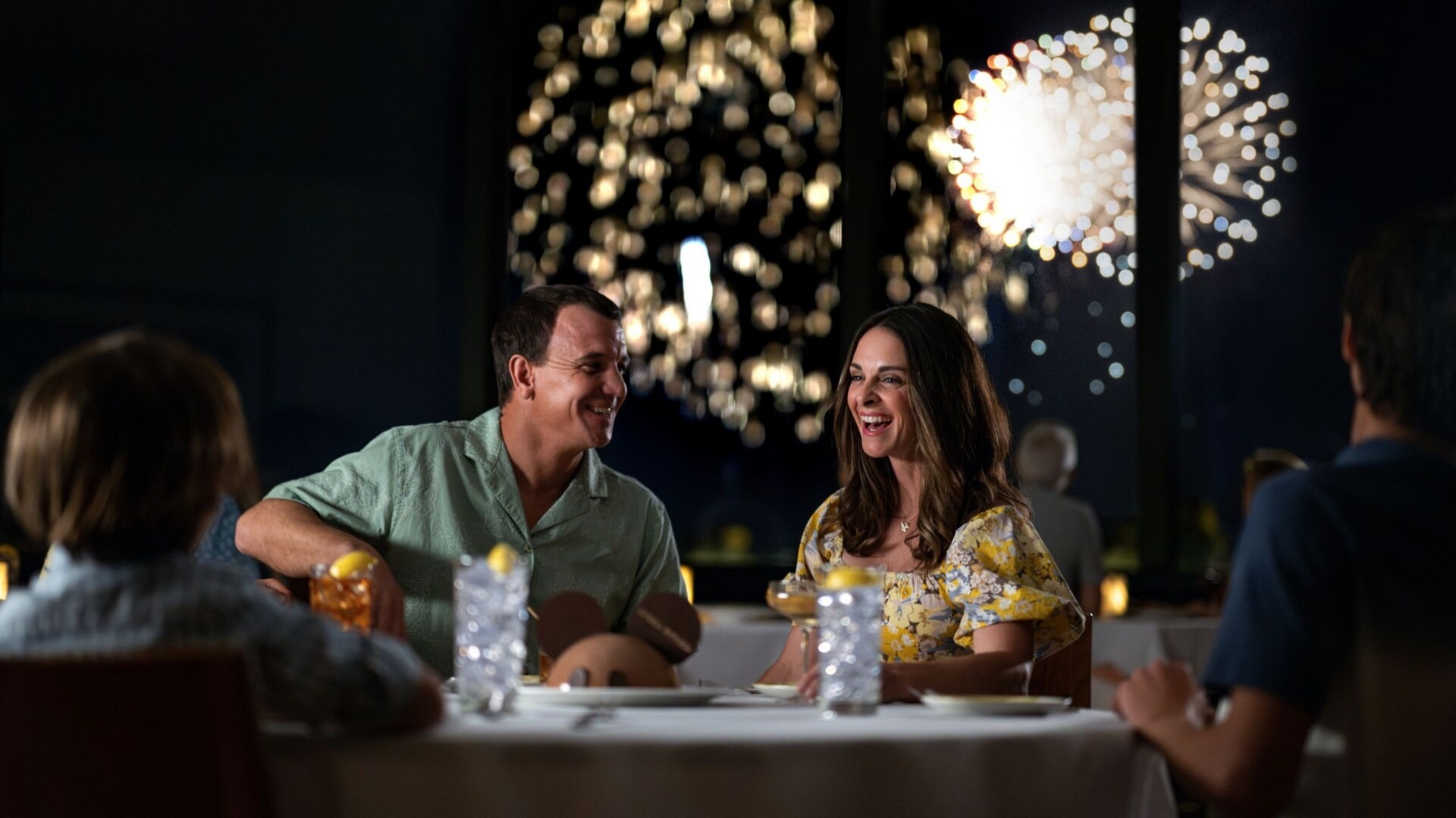 Guests dining at California Grill while fireworks fill the windows behind them