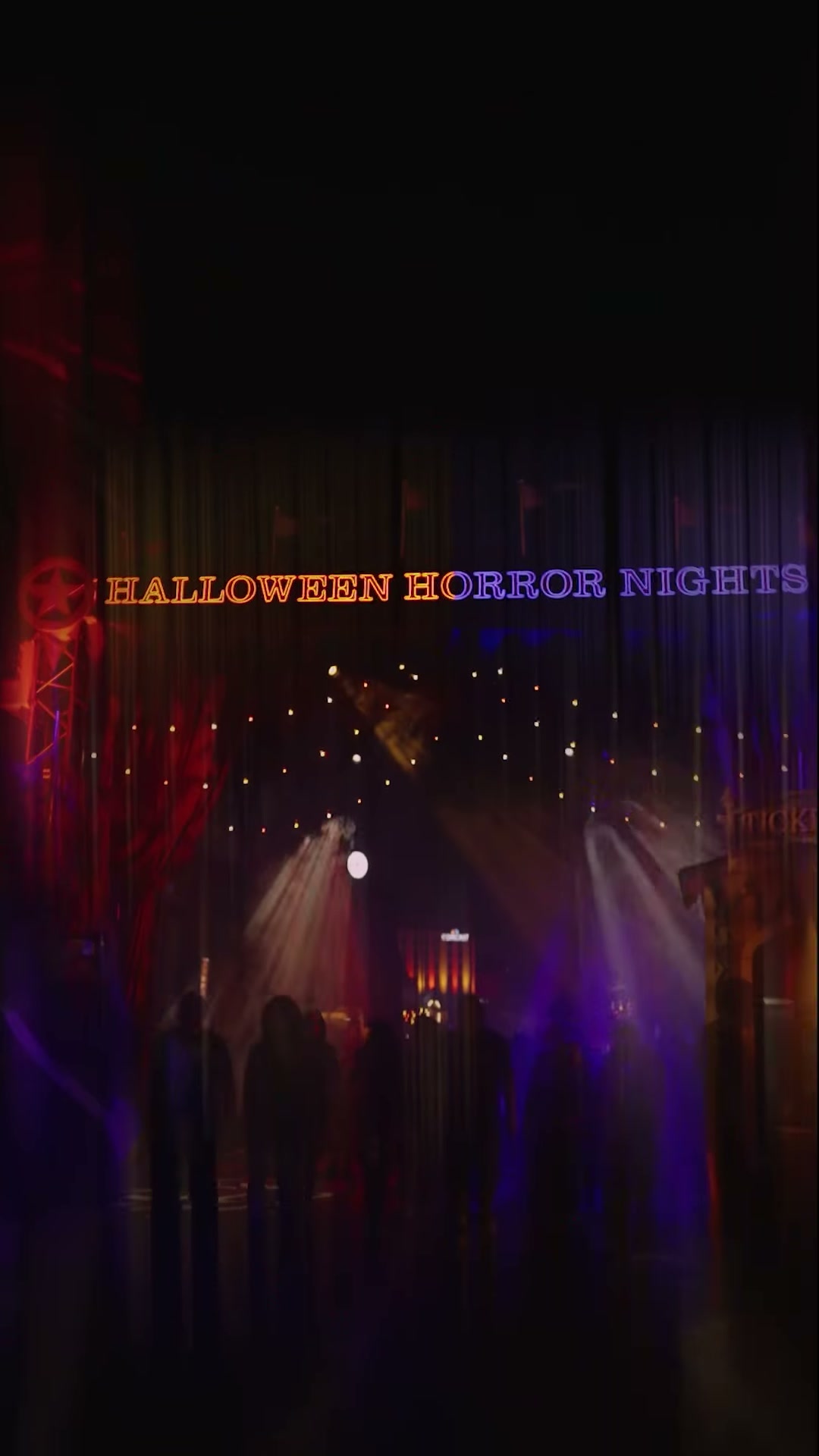 Halloween Horror Nights entrance glowing orange and purple beneath theatrical lights