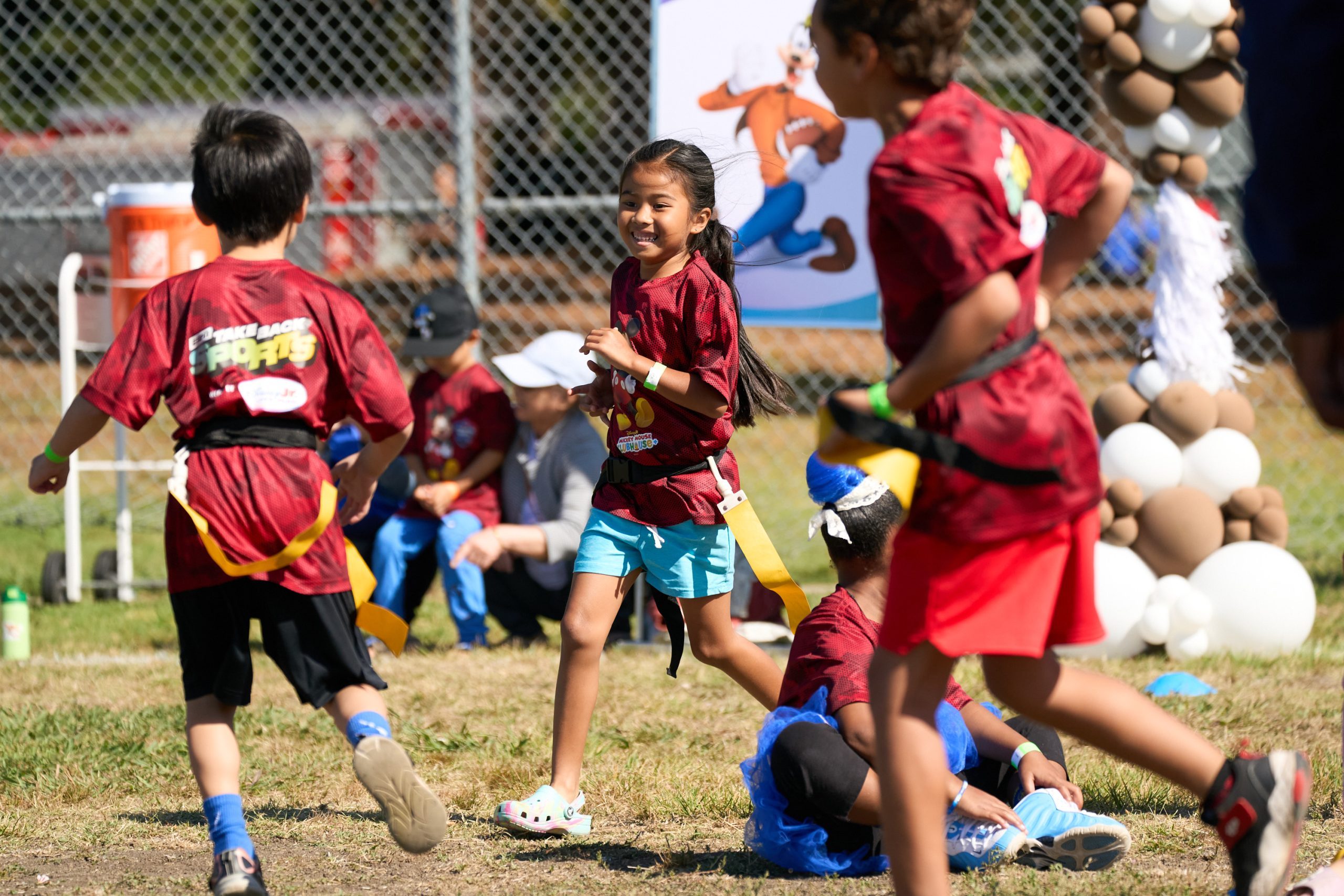 Children play flag football at a Disney Jr. and ESPN youth sports clinic