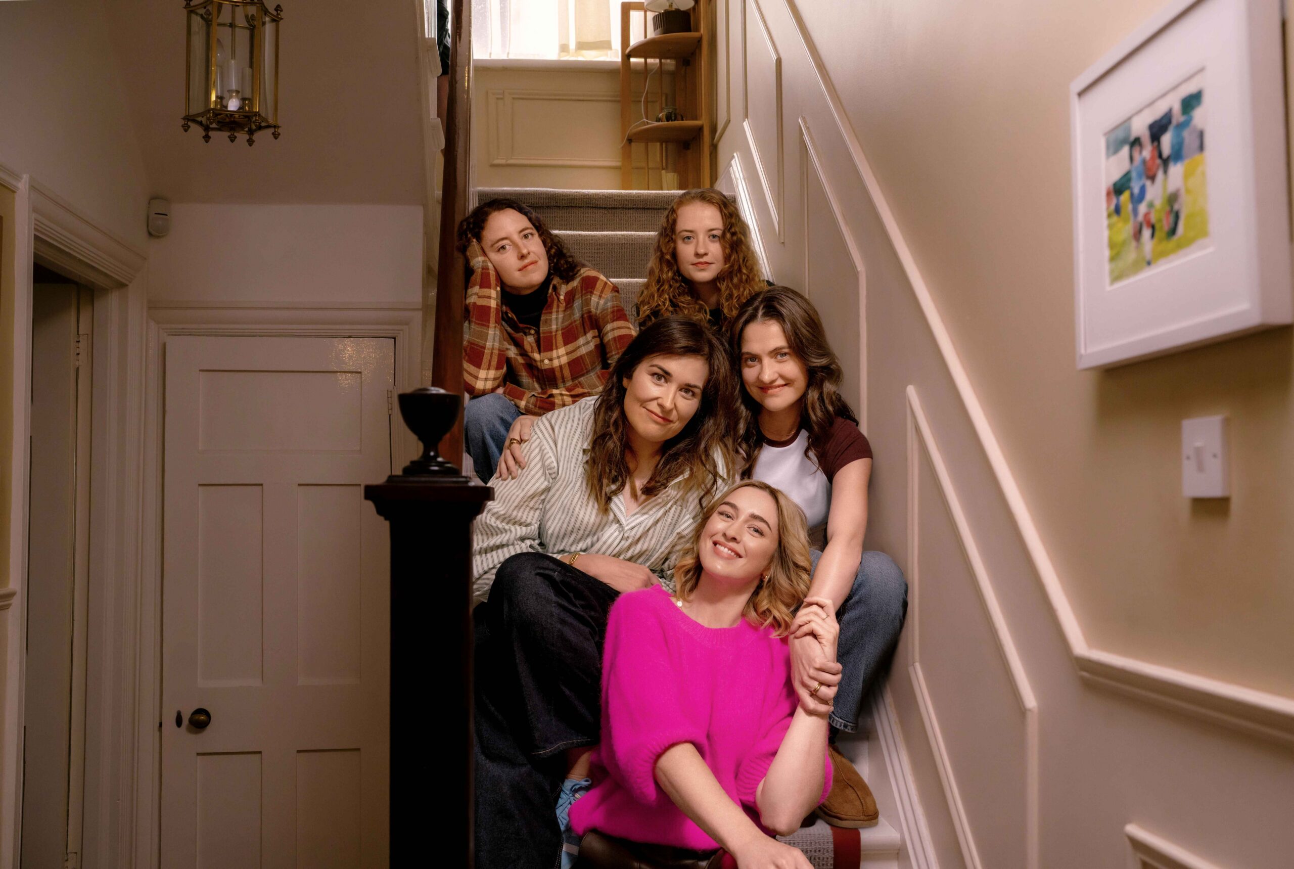 The five Walsh sisters seated together on a staircase