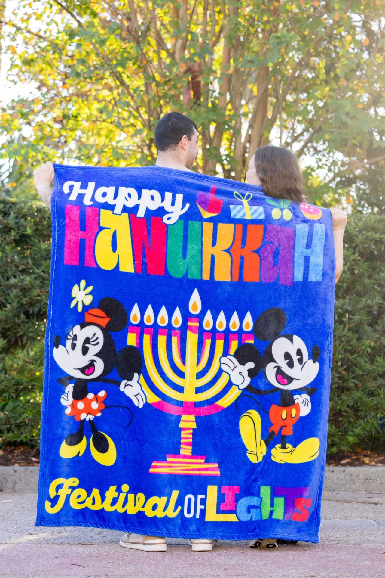 Mickey and Minnie beside a menorah on a blue Hanukkah throw blanket
