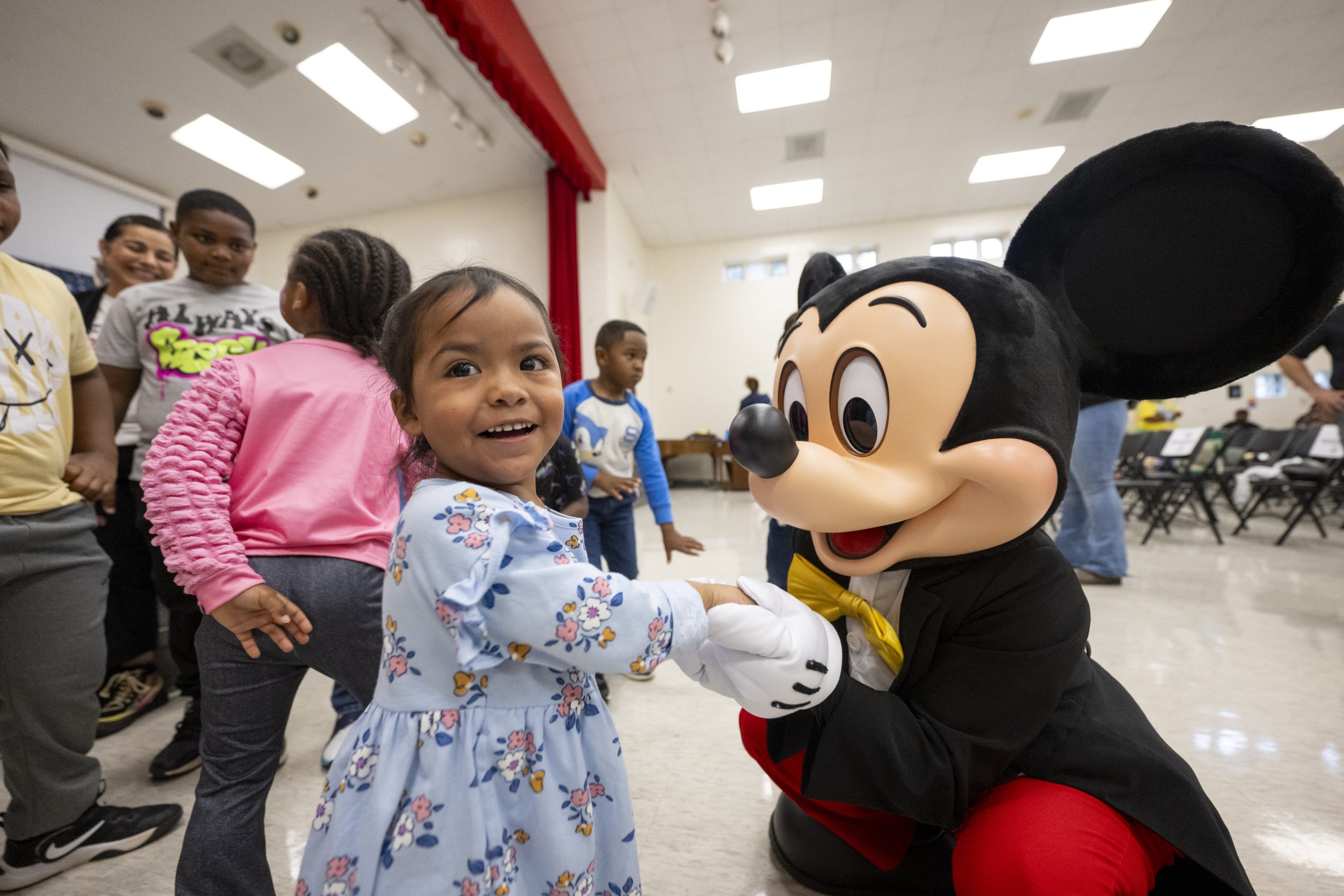 Mickey Mouse greets a child at the Boys and Girls Clubs celebration in Pittsboro