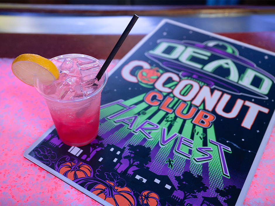 Dead Coconut Club Harvest drink beside the venue’s alien-harvest artwork