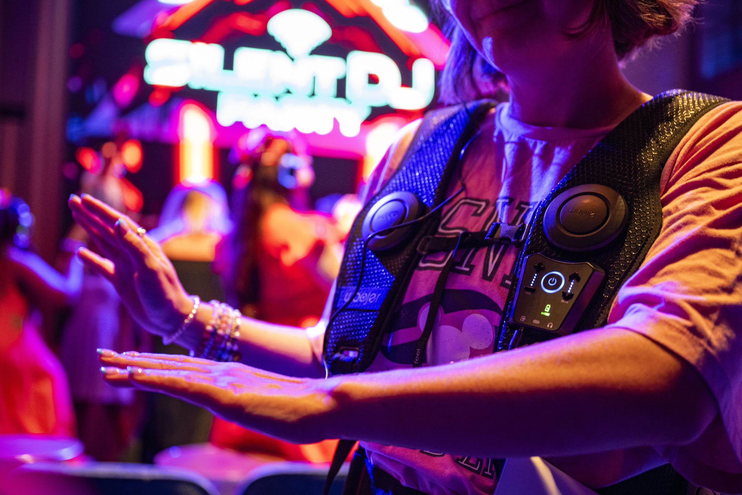A guest wearing a haptic vest at a Disney Cruise Line silent disco
