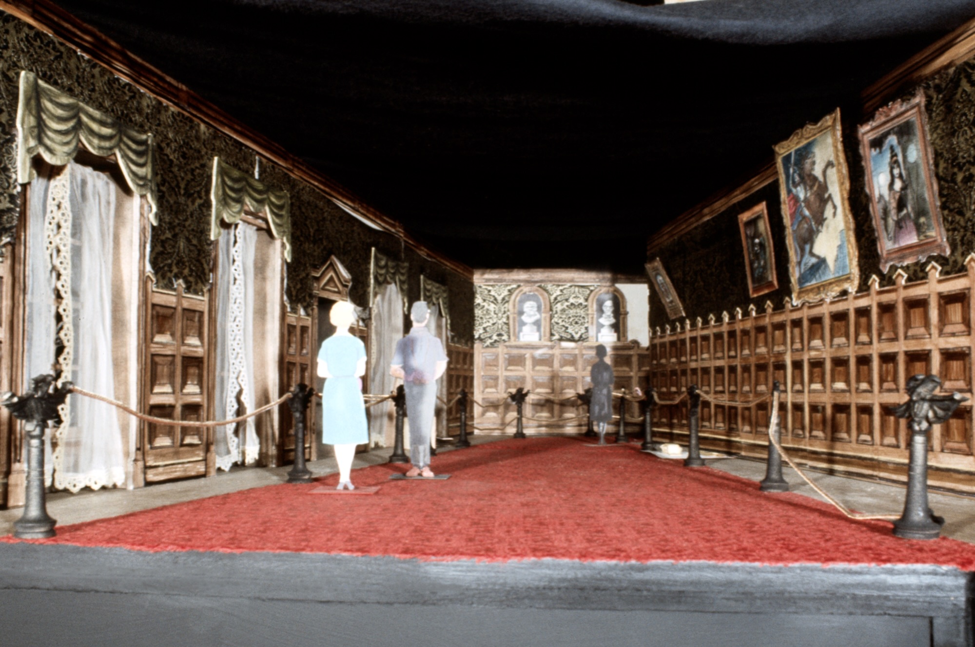 An early Haunted Mansion tabletop model showing its portrait gallery, red carpet and paper figures