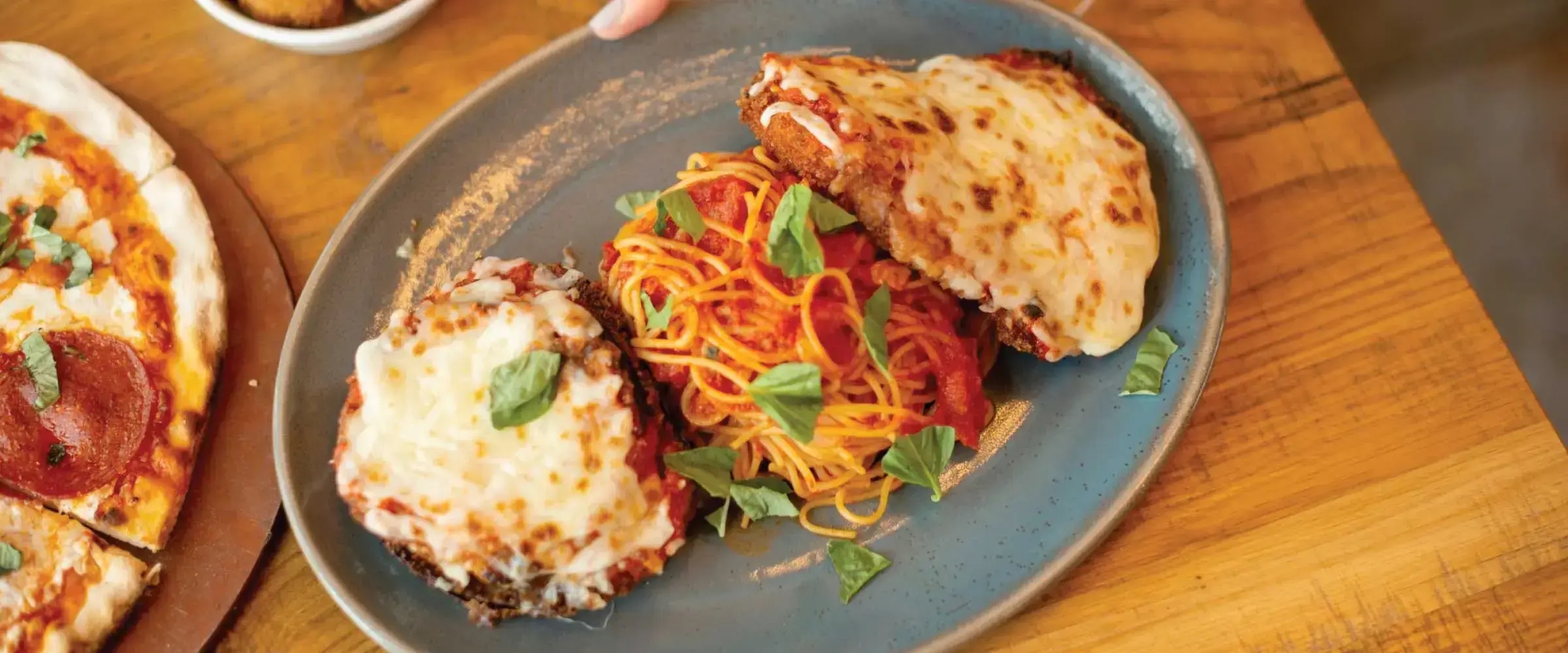 Chicken parmesan, spaghetti and pizza served at Terralina Crafted Italian